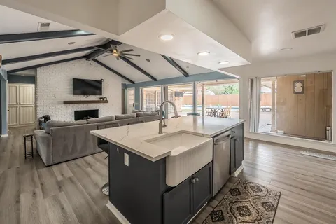 a kitchen with stainless steel appliances granite countertop a sink a microwave oven and a dining table with wooden floor
