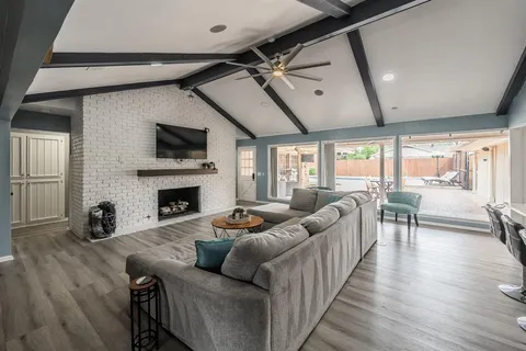 a living room with furniture a fireplace and a flat screen tv