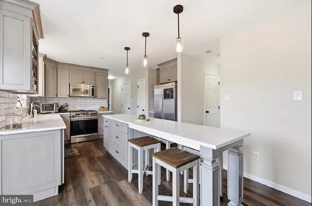 a kitchen with a sink a stove and chairs
