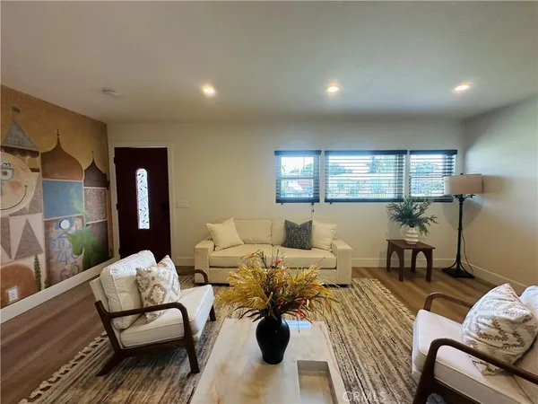 a living room with furniture and wooden floor