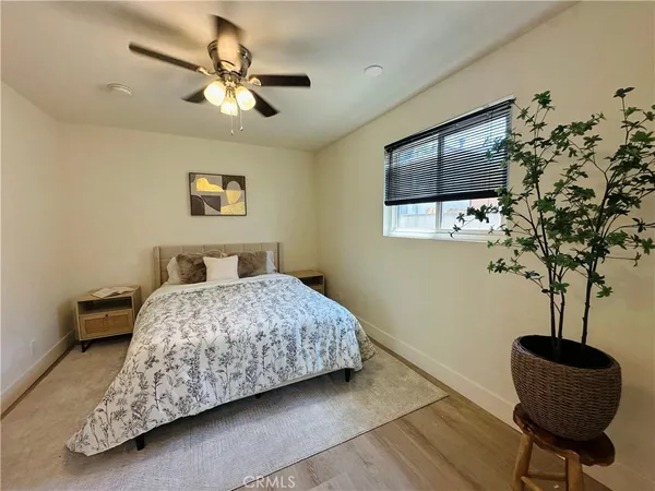 a bedroom with a bed and a potted plant