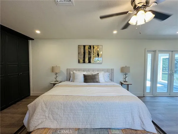 a bedroom with a large bed and a chandelier