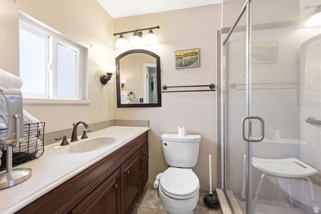 310 South 300 West Payson, UT 84651 - Photo 20 of 42 Bathroom featuring a wood-finish vanity with an integrated sink and countertop, a frameless glass shower enclosure, and a window with white trim