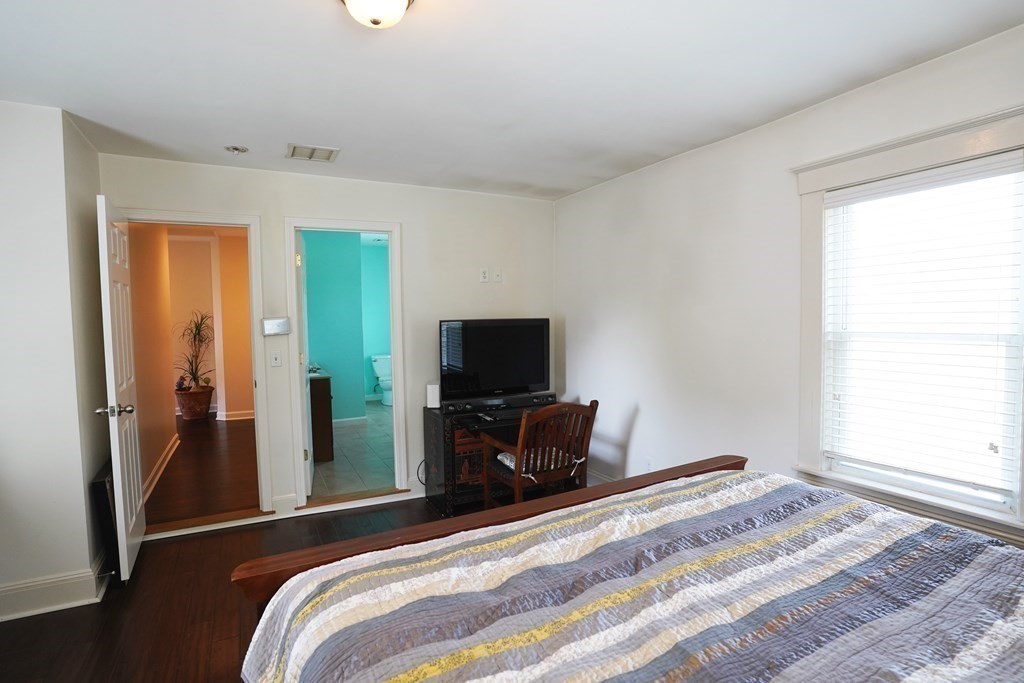 43 Alpine Place Franklin, MA 02038 - Photo 9 of 19 a bedroom with a bed and a flat tv screen on a dresser