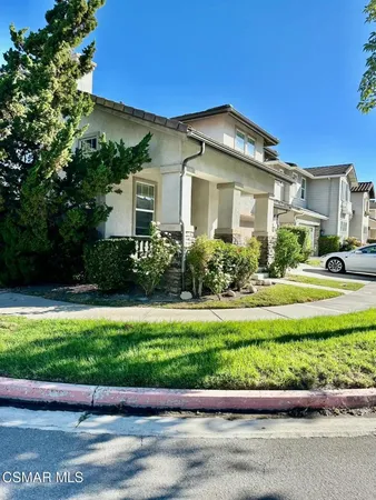 a front view of a house with a yard and potted plants