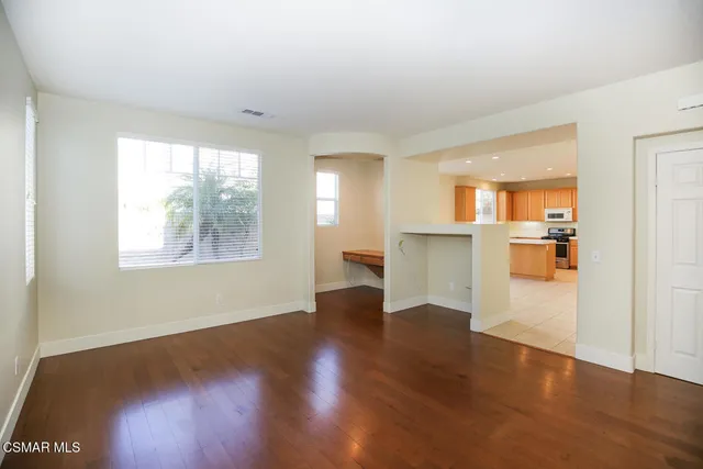 a view of a kitchen with wooden floor and a window