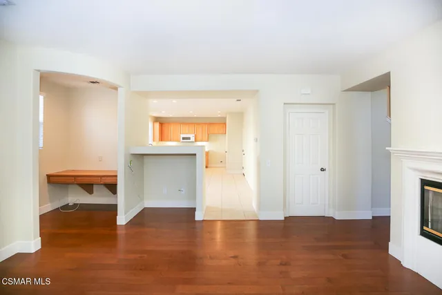 a view of a room with wooden floor and a fireplace