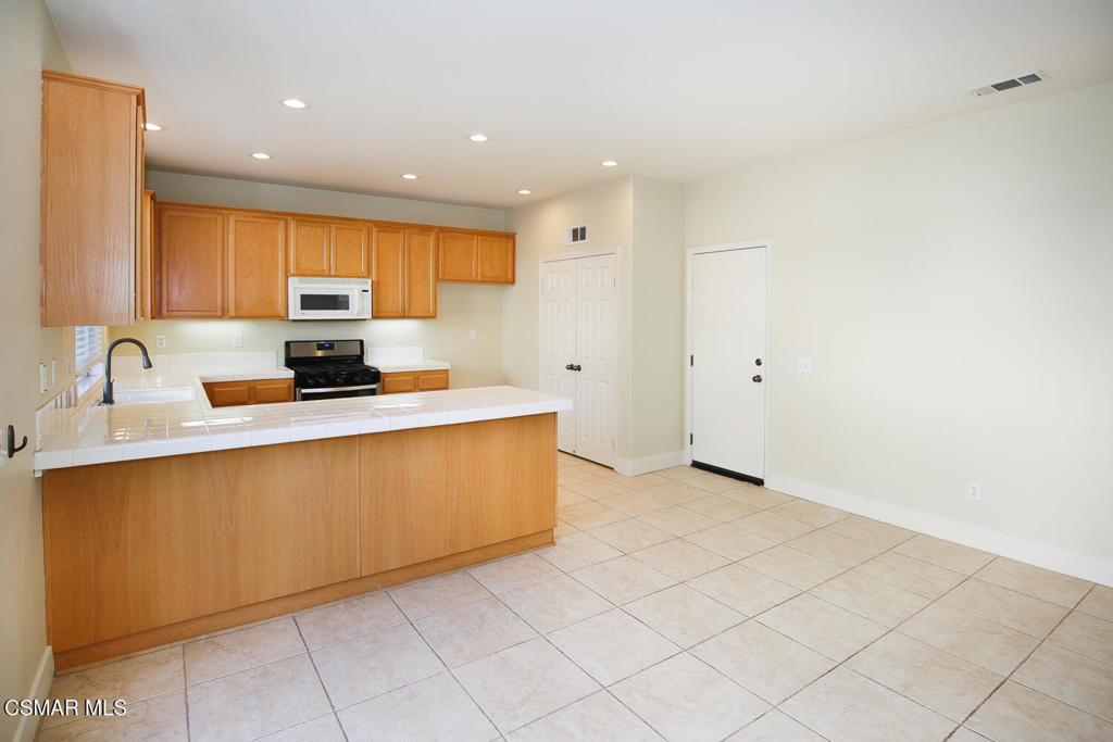 1129 Azalea Way Simi Valley, CA 93065 - Photo 17 of 49 a kitchen with stainless steel appliances a sink a stove a microwave a sink a refrigerator and cabinets