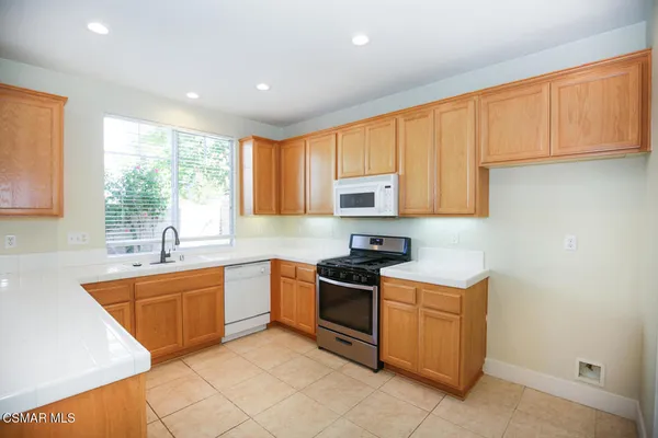 a kitchen with stainless steel appliances granite countertop a sink stove and cabinets