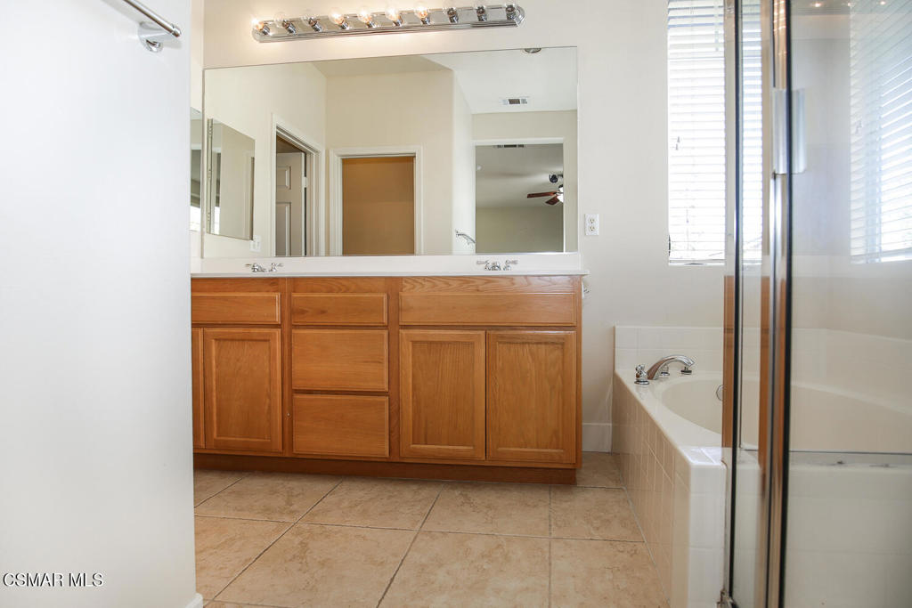 1129 Azalea Way Simi Valley, CA 93065 - Photo 30 of 49 a bathroom with a double vanity sink a mirror and a bathtub