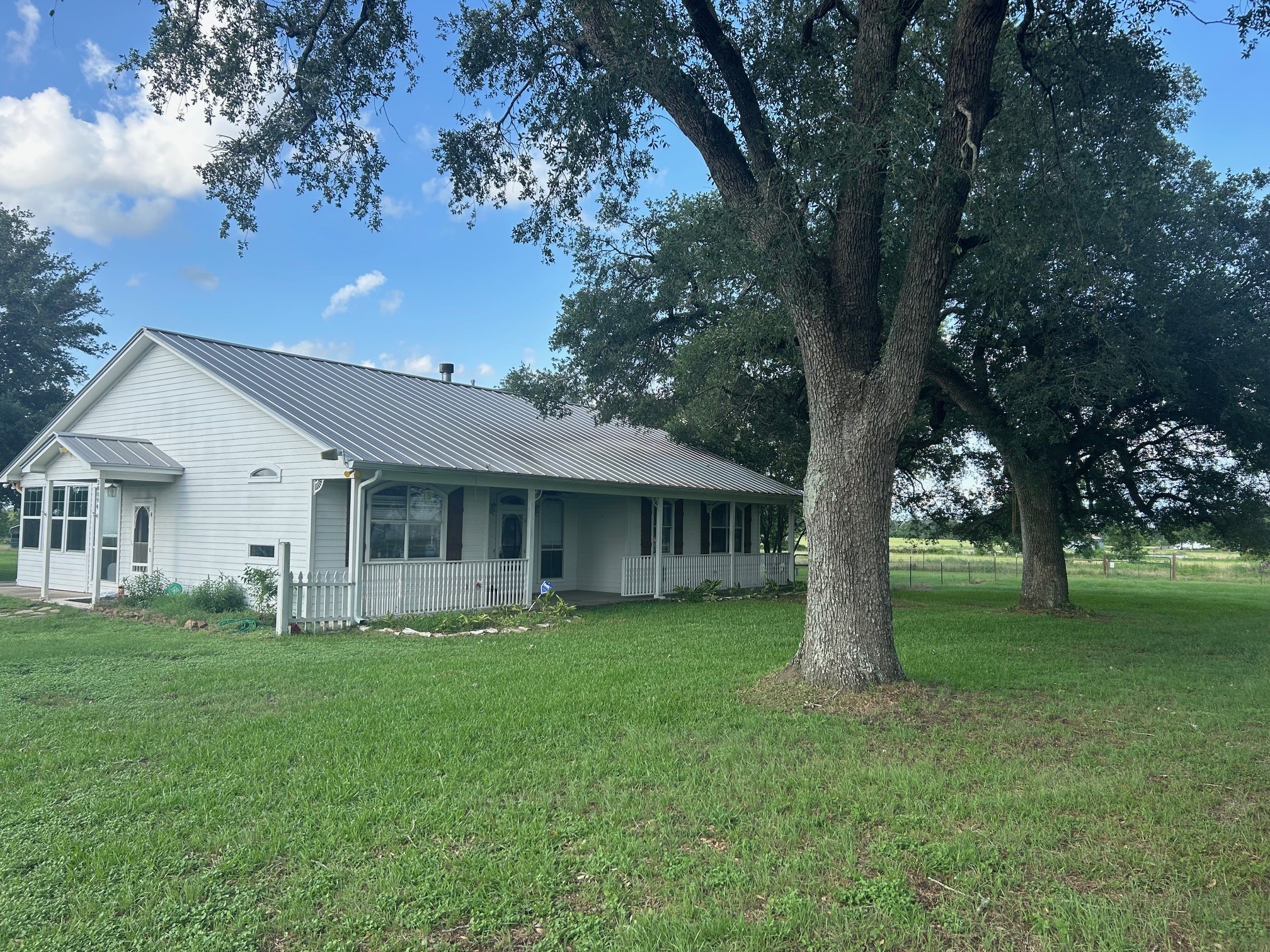 a front view of house with a garden and trees