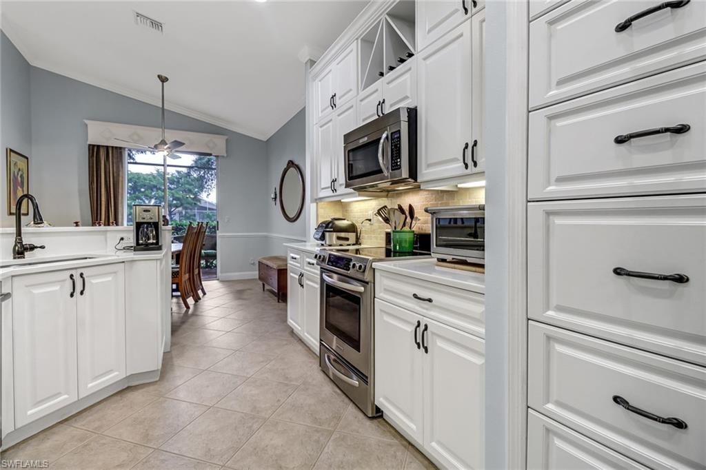 9157 Springview Loop Estero, FL 33928 - Photo 7 of 47 a kitchen with stainless steel appliances granite countertop white cabinets and window