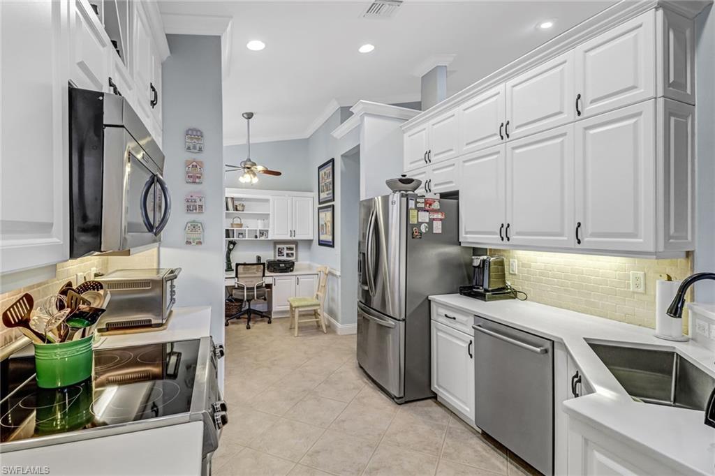 9157 Springview Loop Estero, FL 33928 - Photo 9 of 47 a kitchen that has a lot of cabinets a sink and appliances