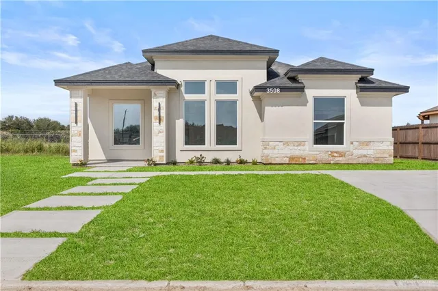 a front view of a house with yard and green space