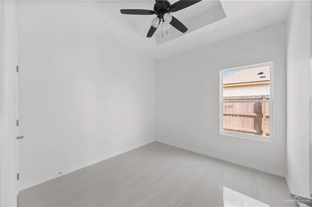 an empty room with a window and a fan