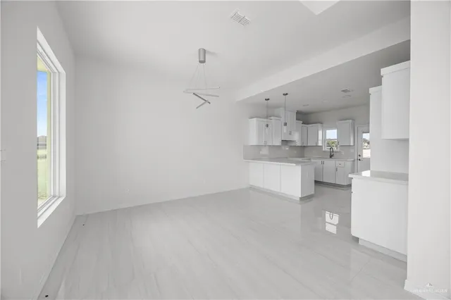 a view of open kitchen with white cabinets and wooden floor