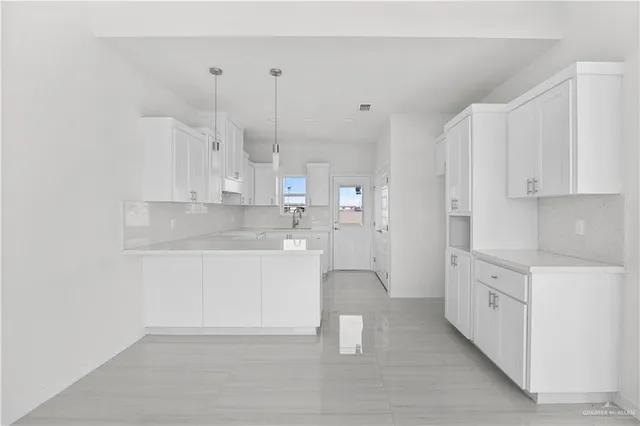 a large white kitchen with white cabinets and a sink