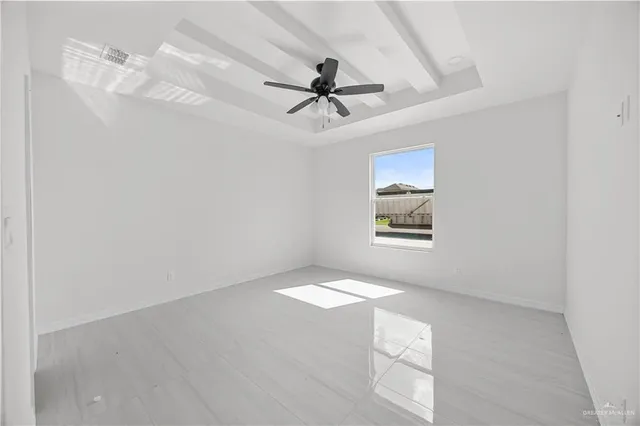 an empty room with windows and fan