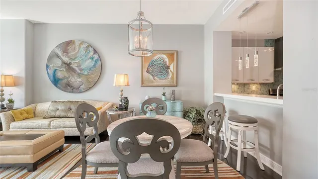 a dining room with furniture a chandelier and wooden floor