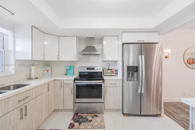 a kitchen with a refrigerator sink and white cabinets