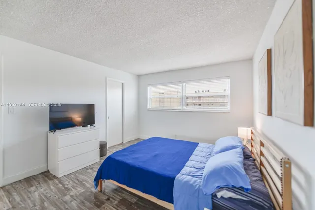 a bedroom with a bed and a flat screen tv