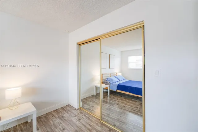 a view of a room that has a bed and wooden floor