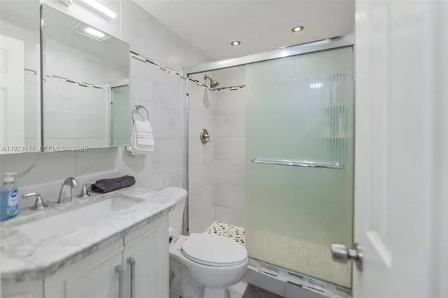 a bathroom with a granite countertop sink toilet and shower