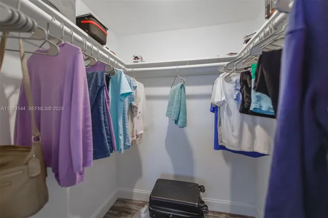 a view of walk in closet with clothes