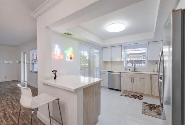 a kitchen with a sink cabinets and wooden floor