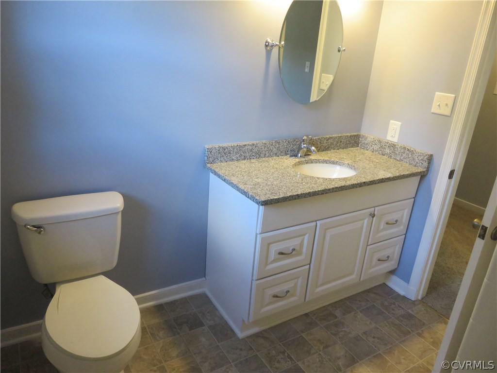8573 Strath Road Henrico, VA 23231 - Photo 24 of 37 a bathroom with a granite countertop toilet sink and mirror