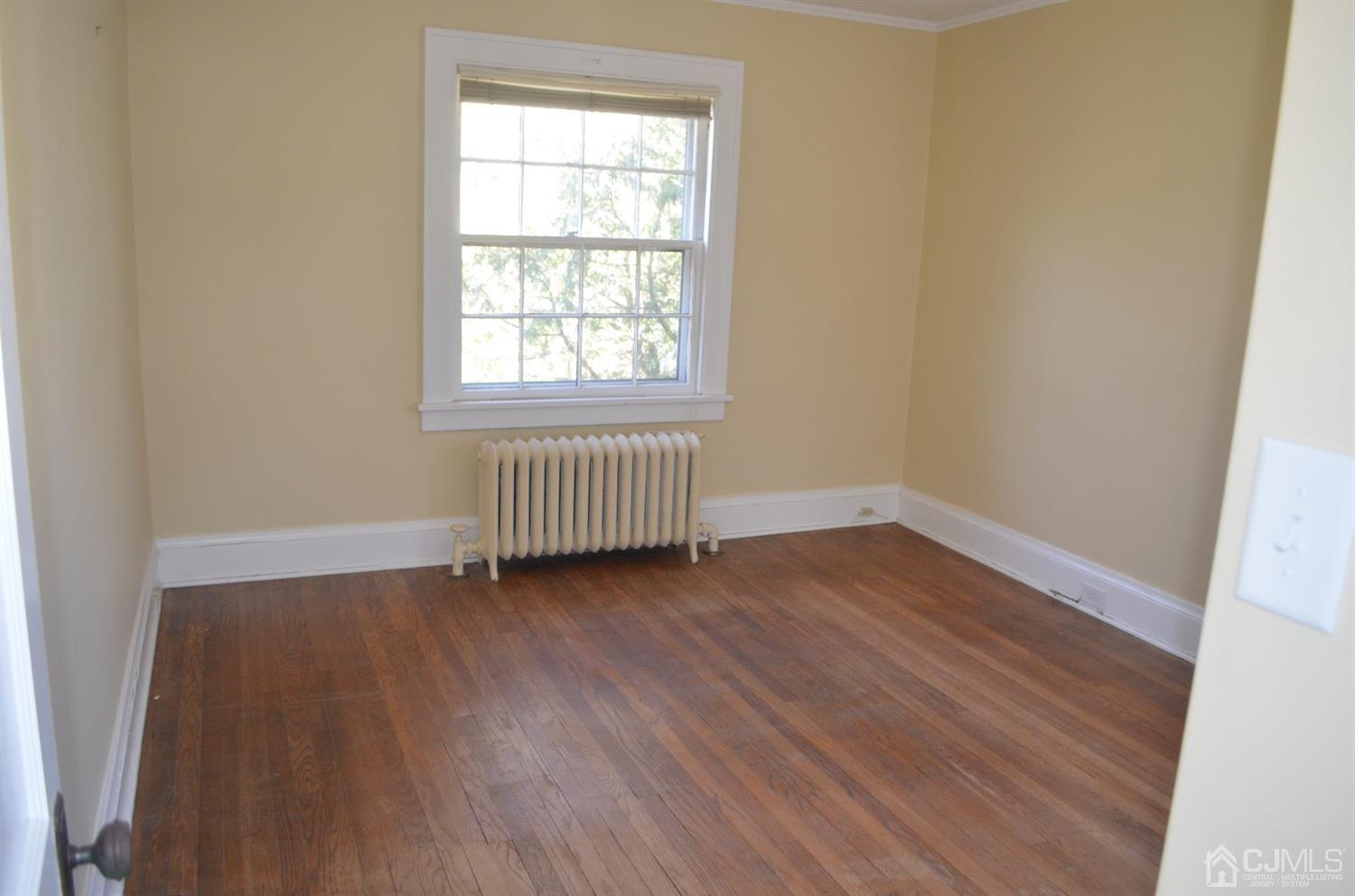 75 West Hill Road Colonia, NJ 07067 - Photo 25 of 35 an empty room with wooden floor and windows