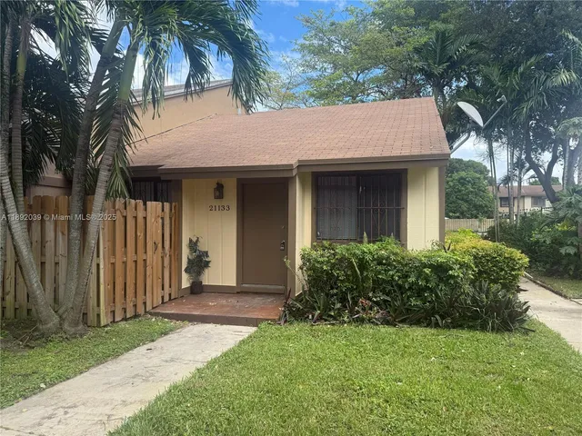 a front view of a house with a garden