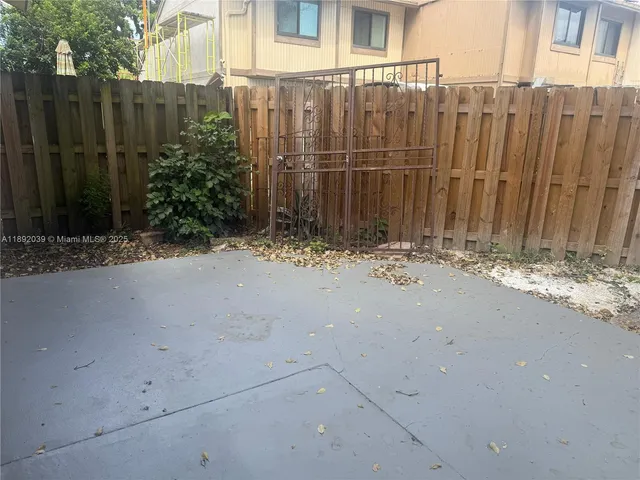a view of a backyard with wooden fence