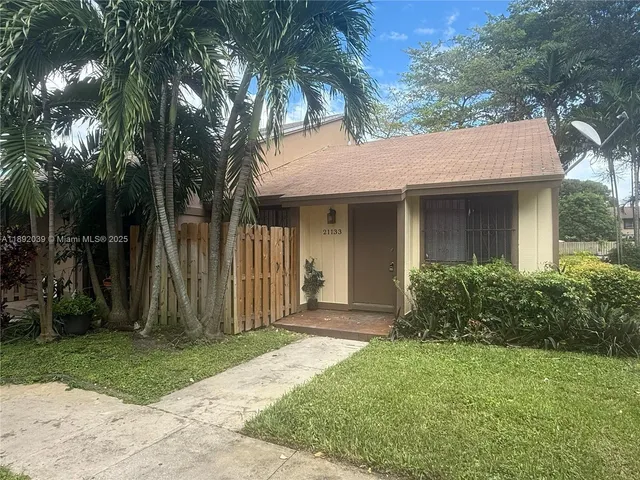 a front view of a house with a garden and plants