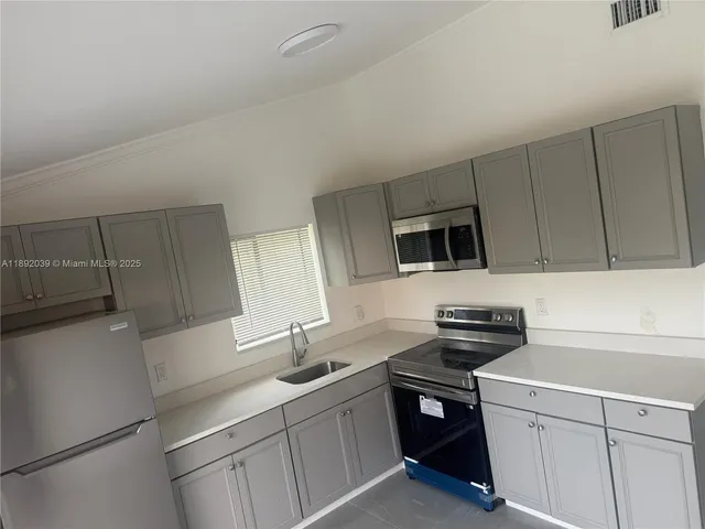 a kitchen with a sink stainless steel appliances and cabinets