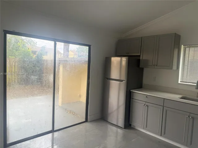 a view of a kitchen with a refrigerator cabinets and a wooden floor