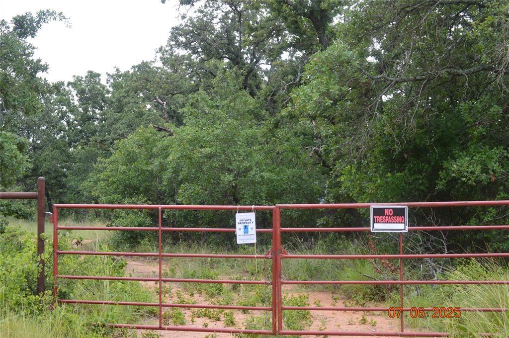 a view of a wooden fence and trees