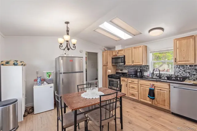 a kitchen with refrigerator cabinets dining table and wooden floor