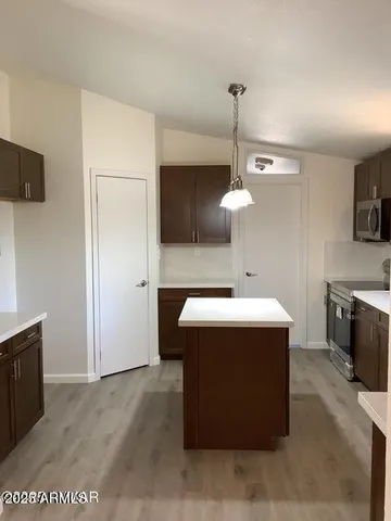 a kitchen with kitchen island stainless steel appliances a stove refrigerator and microwave