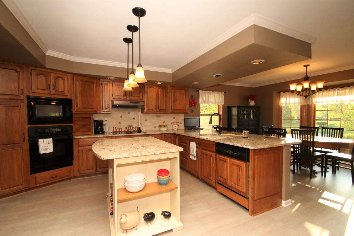 11627 Prestwick Road Belvidere, IL 61008 - Photo 10 of 25 a kitchen with a stove a refrigerator and chairs