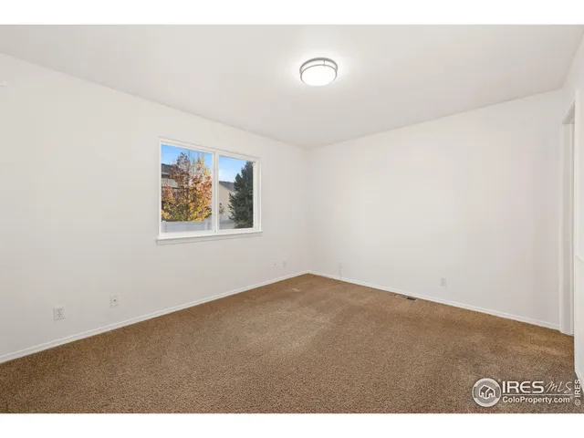 a view of empty room with a fireplace and wooden floor