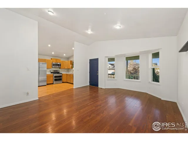a view of empty room with wooden floor