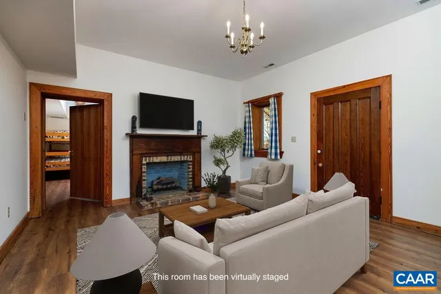 a view of an entryway with wooden floor fireplace and a window