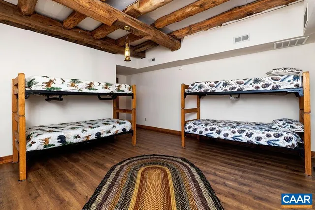 a view of a bedroom with wooden floor and window
