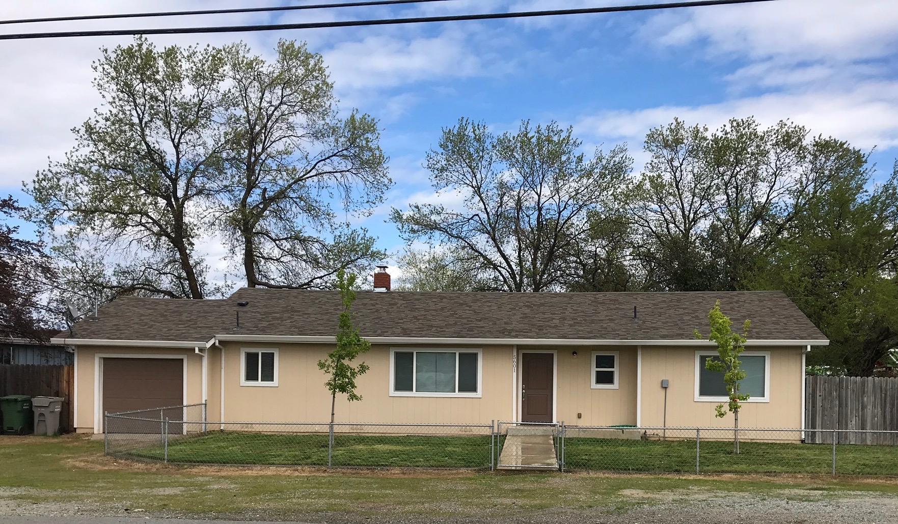 a front view of a house with a garden and yard
