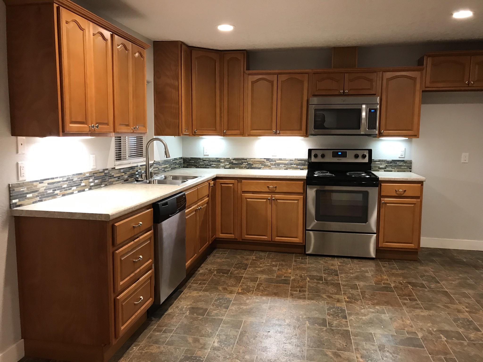5601 Eastside Road Redding, CA 96001 - Photo 5 of 22 a kitchen with stainless steel appliances granite countertop a stove top oven sink and cabinets