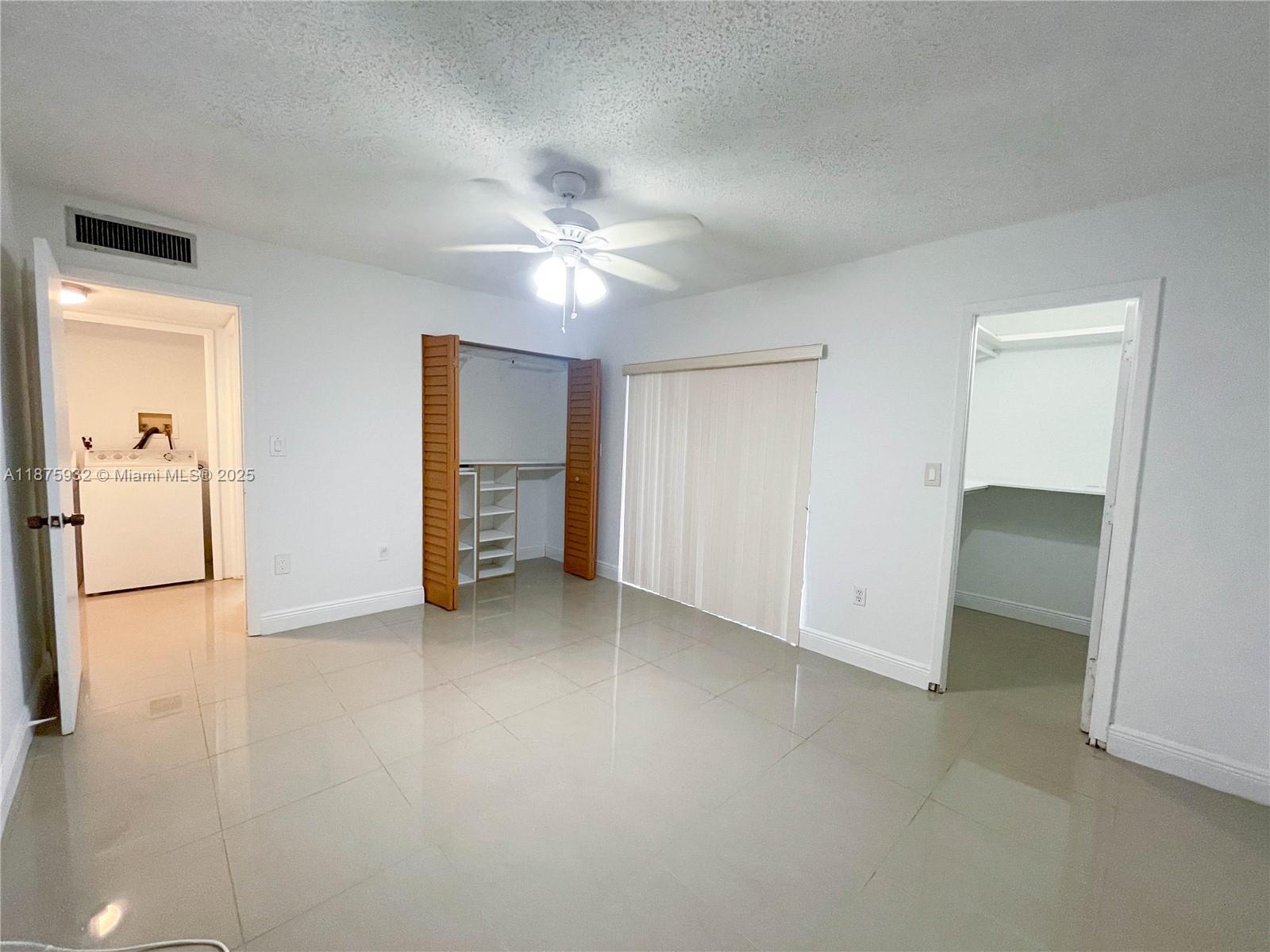 10370 Southwest 220th Street, Unit 129 Miami, FL 33190 - Photo 2 of 8 an empty room with closet and a chandelier fan