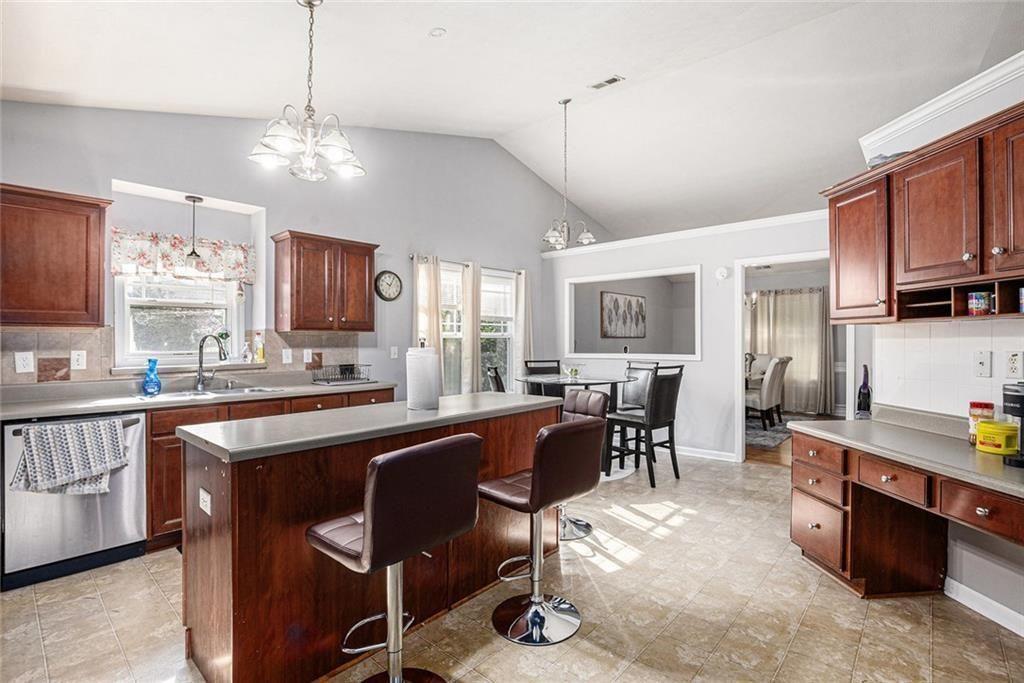 615 Hemlock Court Villa Rica, GA 30180 - Photo 13 of 31 a large kitchen with cabinets chairs and stainless steel appliances