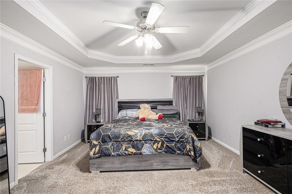615 Hemlock Court Villa Rica, GA 30180 - Photo 17 of 31 a bedroom with a bed and a chandelier