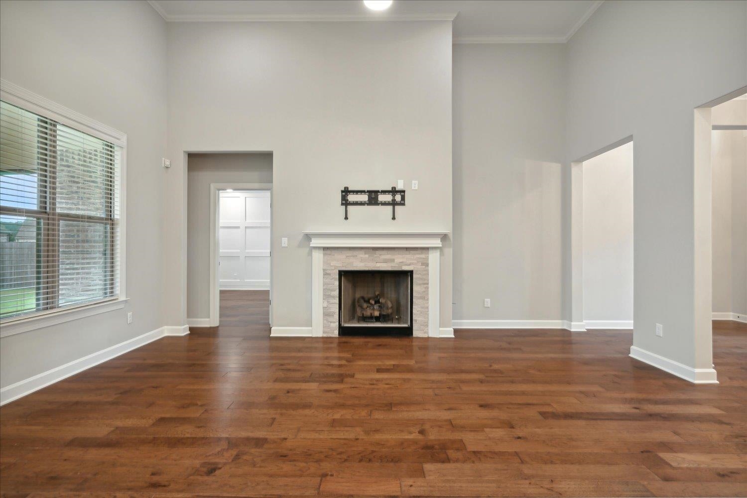 6437 Rutherford Circle Arlington, TN 38002 - Photo 11 of 40 Unfurnished living room with a high ceiling, ornamental molding, and dark hardwood / wood-style floors